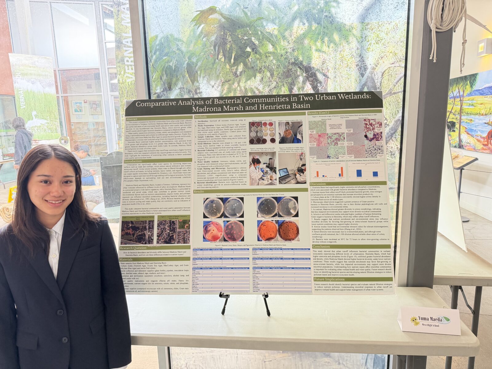 Yuma Maeda standing with her Expo display