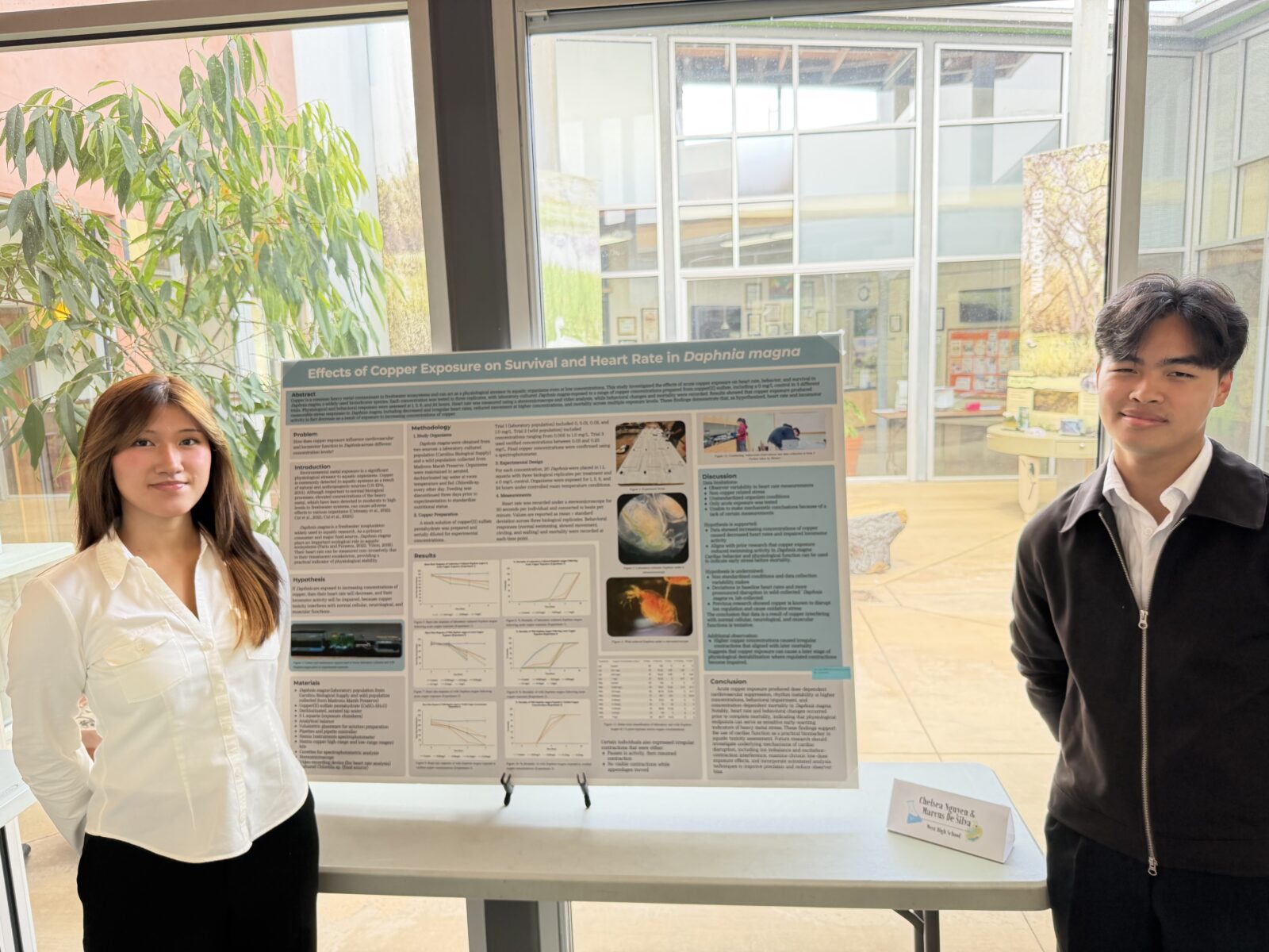 Chelsea Nguyen & Marcus De Silva standing with their Expo display